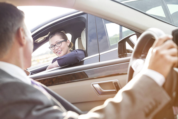 Üzletasszony beszél ügyvezető autóban ülve mosolyogva - Fotó, kép
