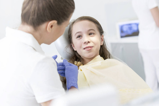 Doctor checking girl patient at dental clinic - Φωτογραφία, εικόνα