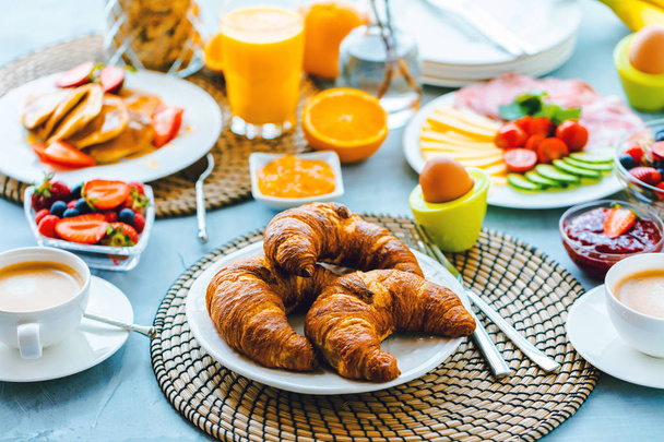 Śniadanie z kawa, sok pomarańczowy, rogaliki, płatki i owoce. Zrównoważona dieta. - Zdjęcie, obraz