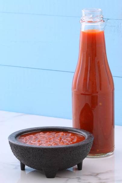 Ремесленная мексиканская горячая сальса в винтажной талавере, с вкусным свежим горячим вкусом, на винтажном мраморном столе из каррары
. - Фото, изображение