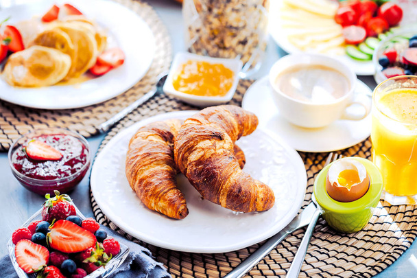 Ontbijt met koffie, sinaasappelsap, croissants, ontbijtgranen en fruit. Evenwichtige voeding. - Foto, afbeelding