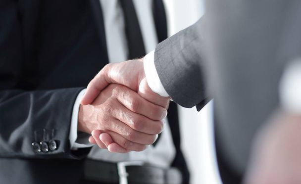 Friendly smiling businessmen handshaking. Business concept photo - Foto, Imagen