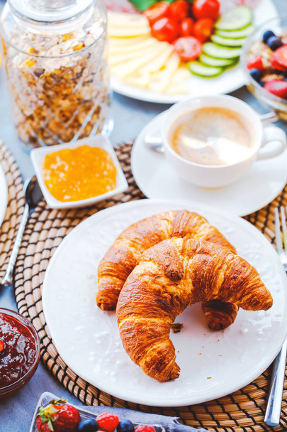 Desayuno servido con café, zumo de naranja, croissants, cereales y frutas. Dieta equilibrada
. - Foto, imagen