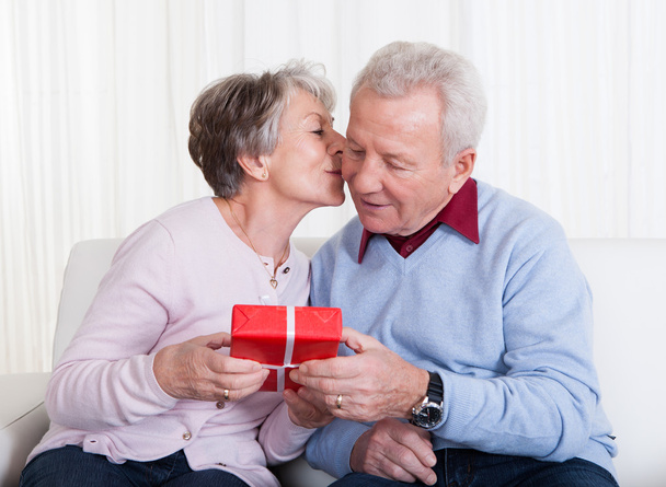 Homme âgé donnant un cadeau à une femme âgée
 - Photo, image