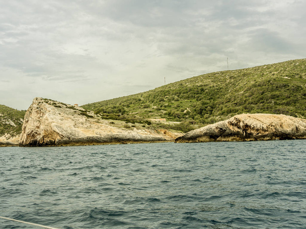 Kivet sinisen luolan sisäänkäynnin saarella Vis Kroatiassa. Laukaus purjeveneestä
. - Valokuva, kuva