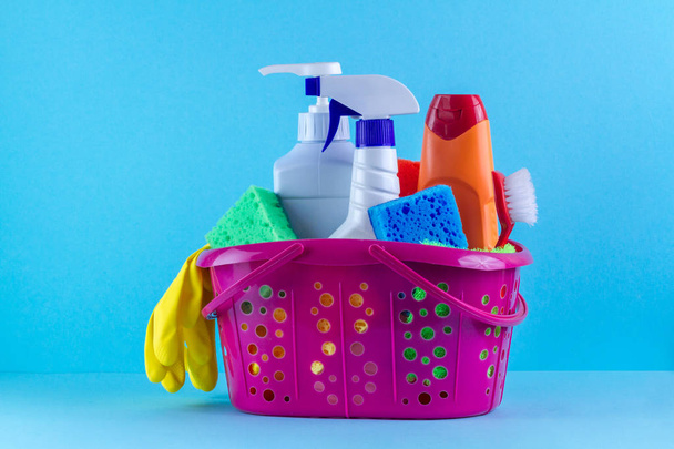 Divers produits pour nettoyer la maison dans un panier sur un fond bleu. Nettoyage
  - Photo, image