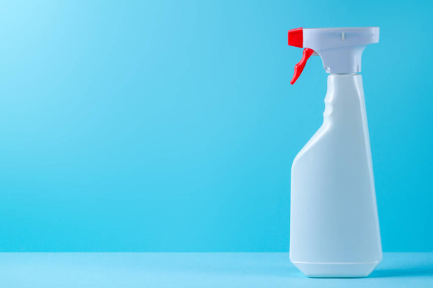 Spray for washing windows on a blue background. Means for cleaning houses. Copy space  - Foto, Imagen