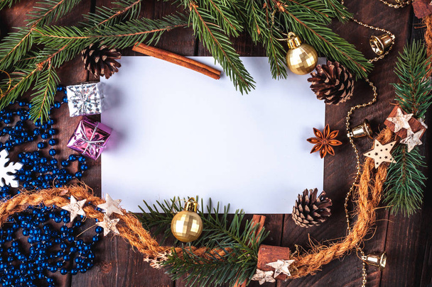 Kerstversiering, ballen, anisee boom, kaneel, kegels, vuren tak, geschenken op een houten achtergrond. De vakantie van Kerstmis en Nieuwjaar. Prettige kerstdagen en gelukkig Nieuwjaar. Kopieer ruimte. Bovenaanzicht. Kerst plat lag en achtergrond  - Foto, afbeelding