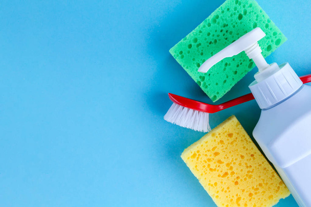 Products for cleaning on a blue background. Cleaning concept. Top view, copy space  - 写真・画像
