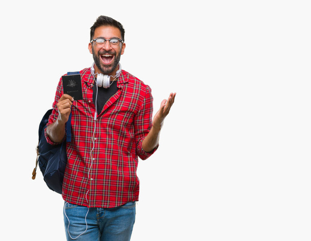 Дорослий латиноамериканського студент людина тримає паспорт Австралії за ізольований фону дуже щасливий і схвильований, переможець вираз святкують перемогу кричала від великий усмішкою і підняв руки - Фото, зображення