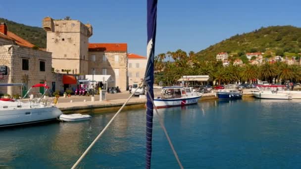 Stadt vis on island vis in croatia gefilmt von Segelbooten Bug. Gefilmt an einem schönen sonnigen Tag beim Verlassen des Stadthafens. - Filmmaterial, Video