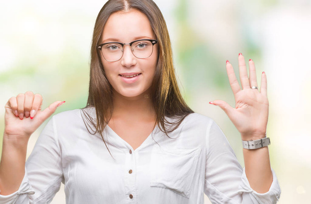 junge kaukasische schöne Geschäftsfrau trägt eine Brille über isoliertem Hintergrund und zeigt mit Finger Nummer sechs nach oben, während sie selbstbewusst und glücklich lächelt. - Foto, Bild