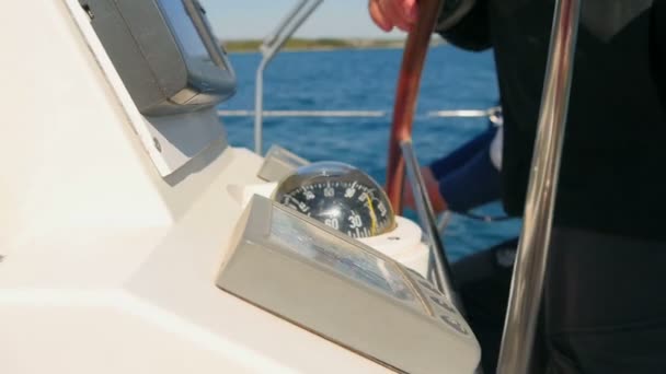 Merimiehet työskentelevät purjehdus venemies kääntämällä ohjauspyörää ja katselee kompassi. Toinen tausta käämitys köydet
. - Materiaali, video