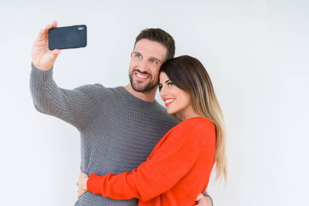 Beautiful young couple in love, kissing and hugging each other taking a selfie picture - Photo, Image