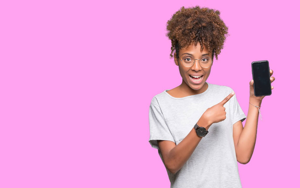 Young african american woman showing smartphone screen over isolated background very happy pointing with hand and finger - Fotografie, Obrázek