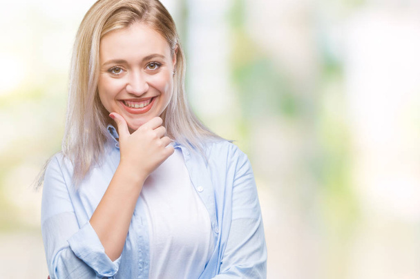 Young blonde woman over isolated background looking confident at the camera with smile with crossed arms and hand raised on chin. Thinking positive. - Foto, afbeelding