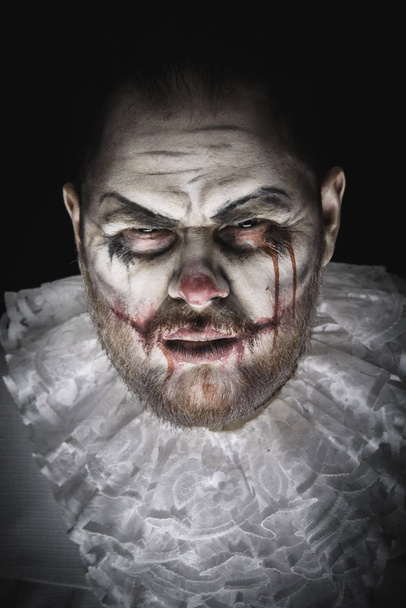 Портрет страшного злого клоуна. Снимок студии с ужасным лицом - Фото, изображение