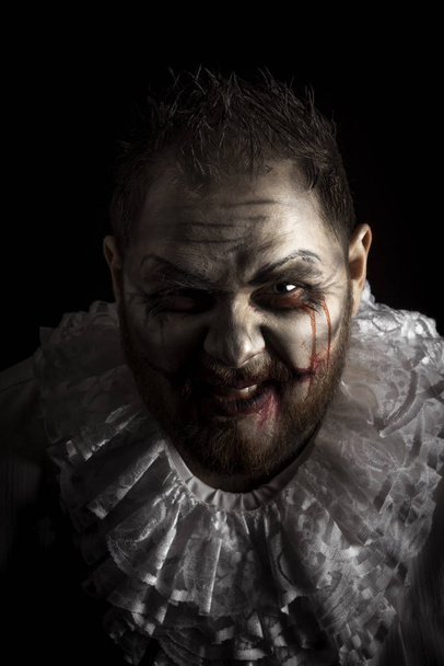 Egy ijesztő gonosz bohóc portréja. Stúdió lövés szörnyű arc art - Fotó, kép