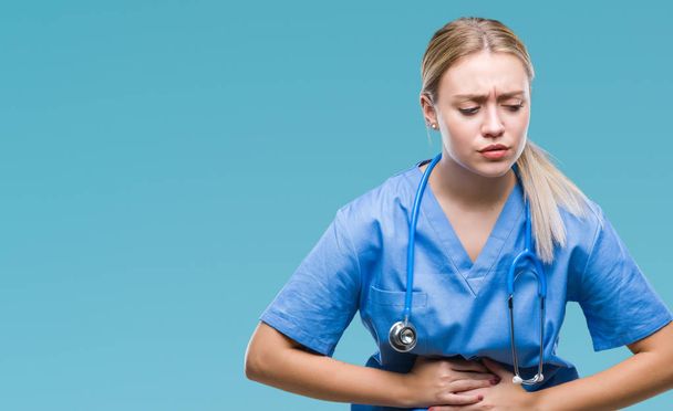 Young blonde surgeon doctor woman over isolated background with hand on stomach because nausea, painful disease feeling unwell. Ache concept. - Foto, Imagen