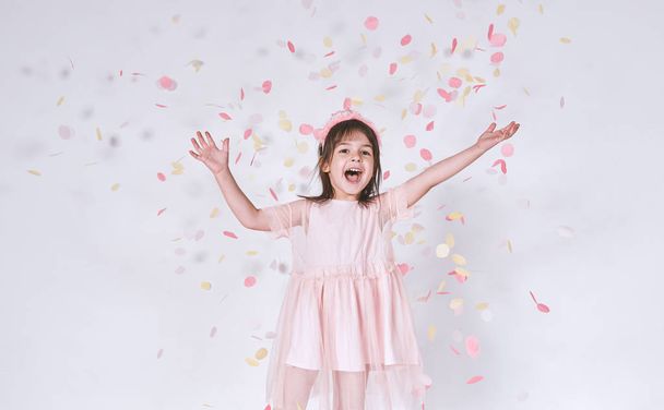 Funny girl with princess crown on head playing with confetti  - Fotografie, Obrázek