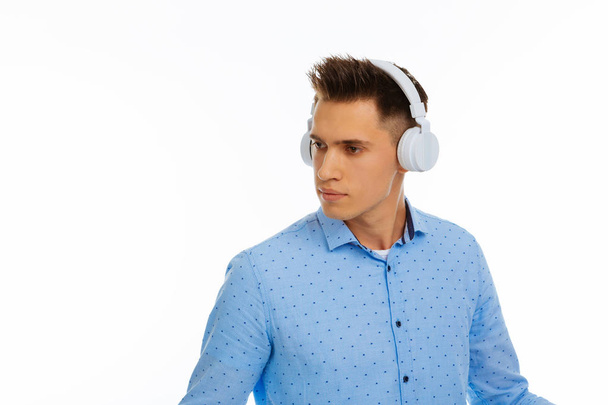 Nice pleasant young man wearing his headphones - Φωτογραφία, εικόνα