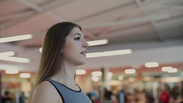 Very beautiful woman exercising on the treadmill in the gym. - Felvétel, videó