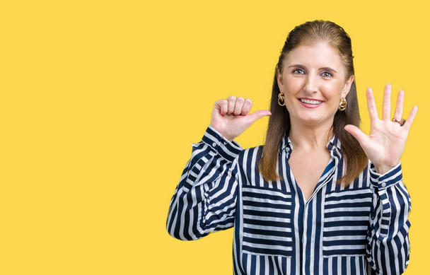 Middle age mature business woman over isolated background showing and pointing up with fingers number six while smiling confident and happy. - Foto, afbeelding