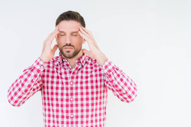 Jonge knappe man shirt dragen over geïsoleerd achtergrond met hand op het hoofd voor pijn in hoofd, omdat stress. Lijden van migraine. - Foto, afbeelding