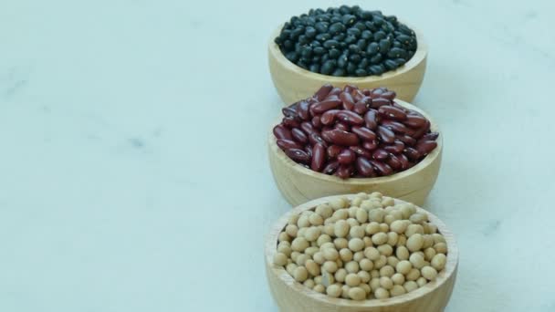 sortiment z fazolí v malých dřevěných misek: červené fazole, sójové boby, fazole mungo - Záběry, video