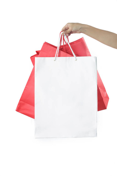 Ręka z torby papierowe na białym tle - strzelać studio, zakupy i konsumpcjonizmu koncepcja - Zdjęcie, obraz