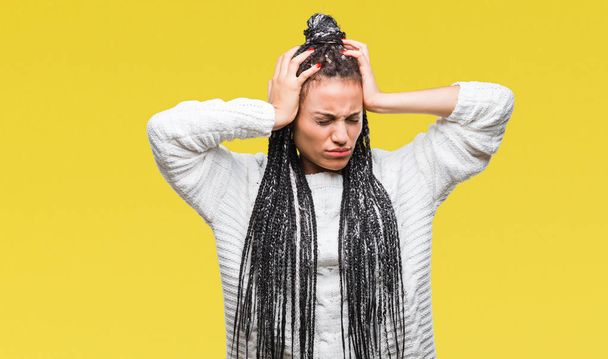 Giovane capelli intrecciati ragazza afroamericana indossa maglione su sfondo isolato che soffre di mal di testa disperato e stressato perché il dolore e l'emicrania. Mani sopra la testa
. - Foto, immagini