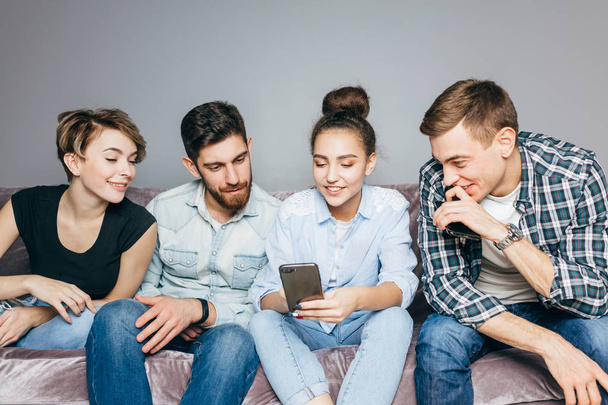 positive young people are reading interesting information from the phone - Φωτογραφία, εικόνα