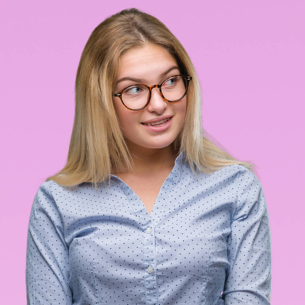 若い白人のビジネス女性で眼鏡をかけて分離背景が笑顔で側に自然な表現の顔に離れています。自信を持って笑ってください。. - 写真・画像