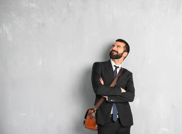 Businessman with beard looking up while smiling - 写真・画像