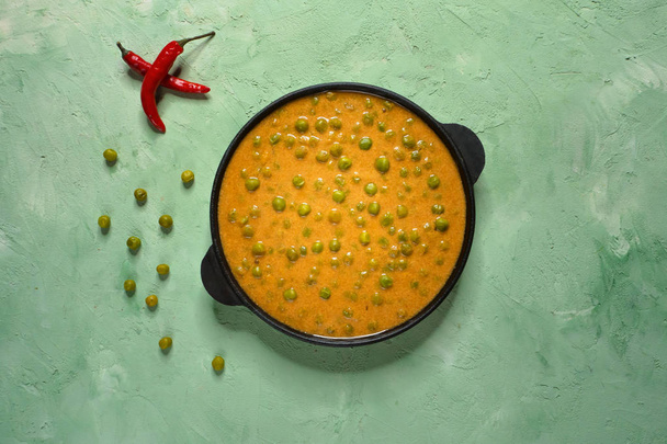 Baked green peas in curry sauce. Indian dish. - Foto, afbeelding