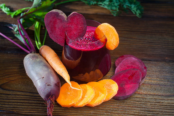 beet-Carrot juice in glass on wooden table - Photo, Image