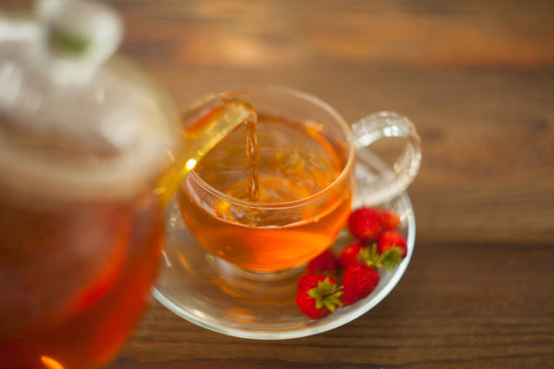 delicious wild strawberry tea in a beautiful glass bowl on a table - Фото, зображення