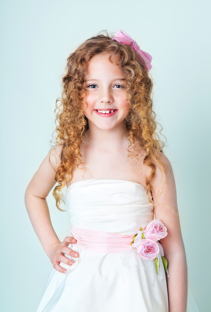 Cute curly child in white dress - Фото, изображение