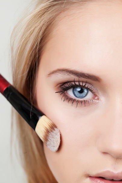 Closeup of woman with makeup brush - Valokuva, kuva