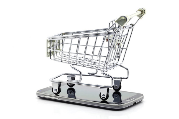 carrito de compras en el teléfono inteligente aislado sobre fondo blanco, concepto de compras en línea de negocios
. - Foto, imagen