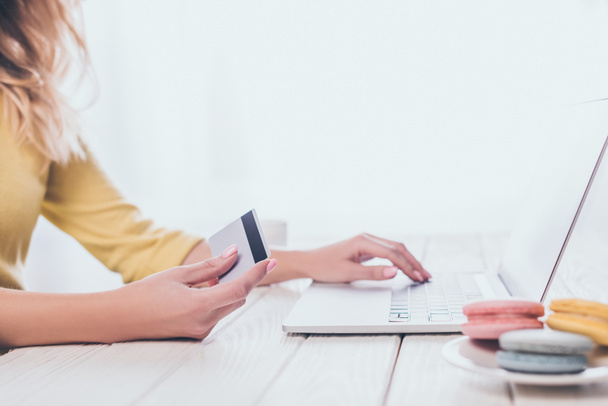 cropped view of woman using laptop while holding credit card  - Foto, Imagen