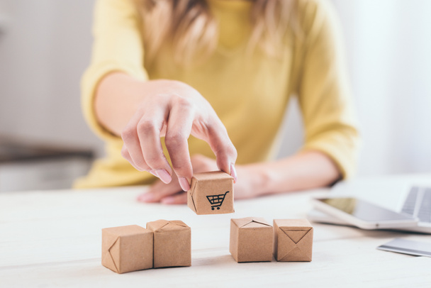 cropped view of woman putting decorative package on table - Photo, Image