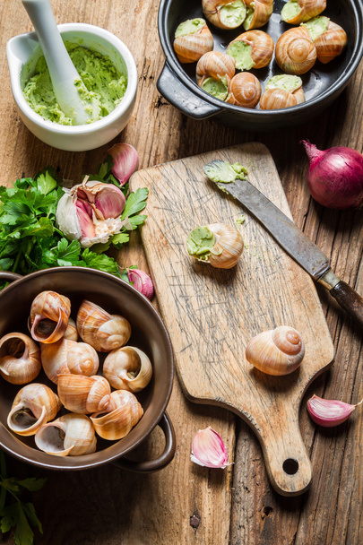 Preparing baked snails with garlic butter - Foto, afbeelding