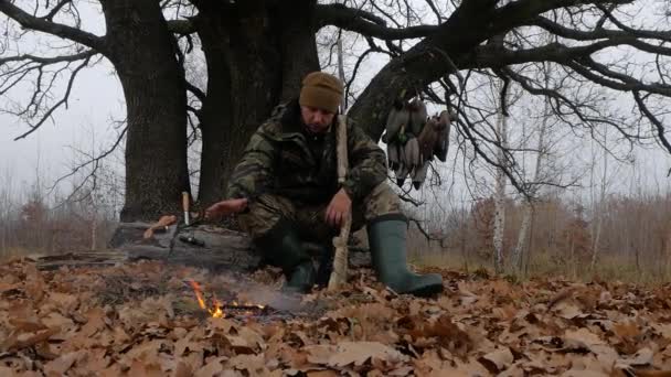 Мисливець з гвинтівки біля вогню - Кадри, відео