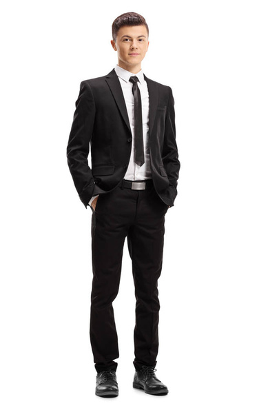 Full length portrait of a young male adult in an elegant suit posing with his hands in pocket isolated on white background - Valokuva, kuva