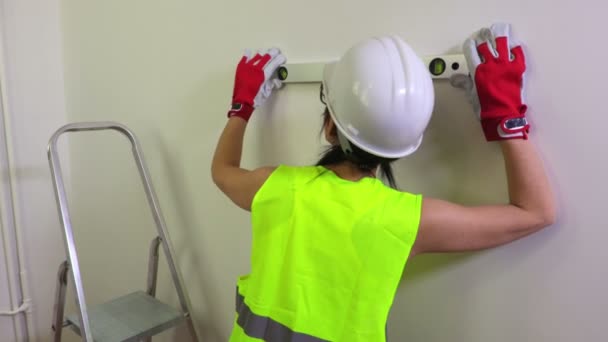 Γυναίκα εργαζόμενος κατασκευή χρησιμοποιώντας αλφάδι - Πλάνα, βίντεο