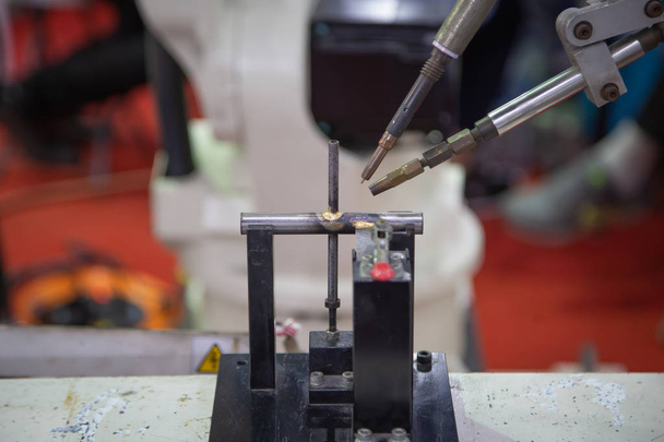 Roboterarm und Schweißmaschine schweißen Stahlwerkstück - Foto, Bild