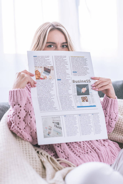 woman reading business newspaper while sitting at home - Photo, Image