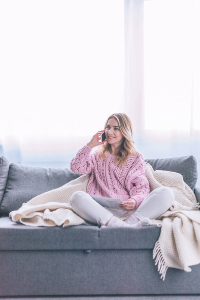 attractive blonde woman talking on smartphone at home  - Foto, afbeelding