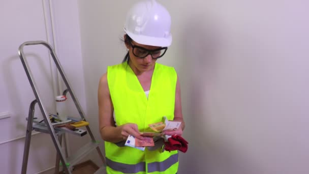 Vrouw bouwvakker geld en shows duim aftellen - Video